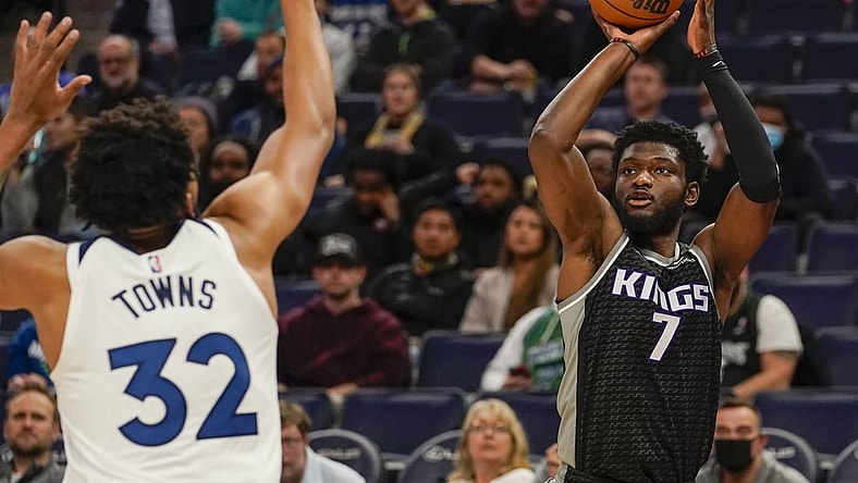Nov 17, 2021; Minneapolis, Minnesota, USA;  Sacramento Kings forward Chimezie Metu (7) shoots a three-pointer as Minnesota Timberwolves center Karl-Anthony Towns (32) defends during the first quarter at Target Center. Mandatory Credit: Nick Wosika-USA TODAY Sports