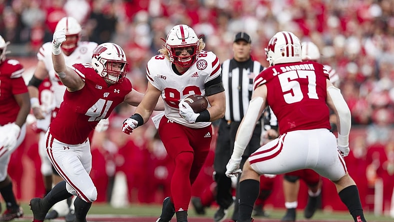 Nov 20, 2021; Madison, Wisconsin, USA;  Nebraska Cornhuskers tight end Travis Vokolek (83) rushes with the football between Wisconsin Badgers linebackers Noah Burks (41) and Jack Sanborn (57) during the first quarter at Camp Randall Stadium. Mandatory Credit: Jeff Hanisch-USA TODAY Sports