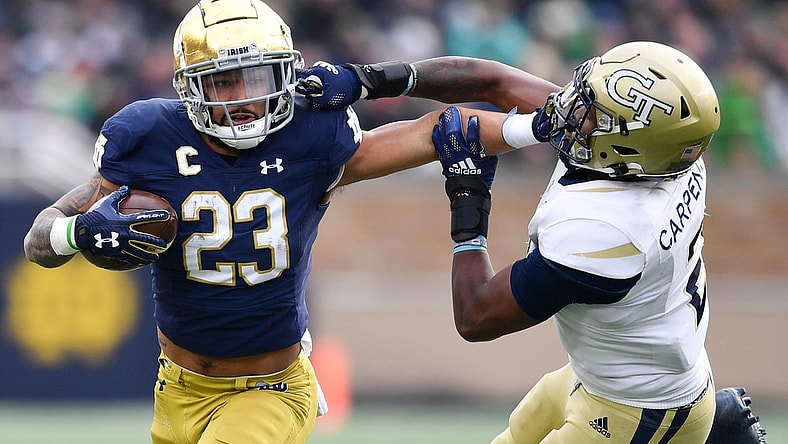 Nov 20, 2021; South Bend, Indiana, USA; Notre Dame Fighting Irish running back Kyren Williams (23) stiff arms Georgia Tech Yellow Jackets safey Tariq Carpenter (2) in the second quarter at Notre Dame Stadium. Mandatory Credit: Matt Cashore-USA TODAY Sports