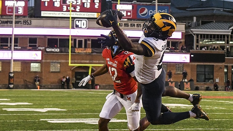 Nov 20, 2021; College Park, Maryland, USA; Michigan Wolverines wide receiver Mike Sainristil (5) catches a one handed touchdown as Maryland Terrapins defensive back Tarheeb Still (12) defends during the first half at Capital One Field at Maryland Stadium. Mandatory Credit: Tommy Gilligan-USA TODAY Sports