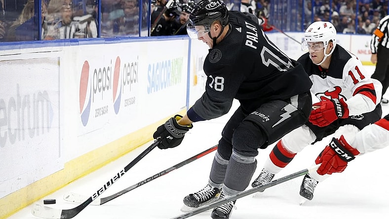 Nov 20, 2021; Tampa, Florida, USA; Tampa Bay Lightning left wing Ondrej Palat (18) passes the puck as New Jersey Devils left wing Andreas Johnsson (11) defends during the second period at Amalie Arena. Mandatory Credit: Kim Klement-USA TODAY Sports
