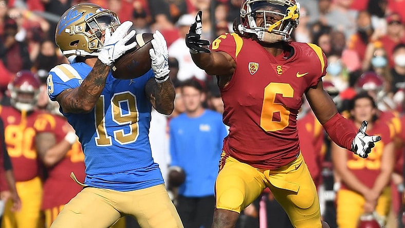 Nov 20, 2021; Los Angeles, California, USA;  UCLA Bruins running back Kazmeir Allen (19) catches a touchdown pass against Southern California Trojans cornerback Isaac Taylor-Stuart (6) in the first half at the Los Angeles Memorial Coliseum. Mandatory Credit: Richard Mackson-USA TODAY Sports