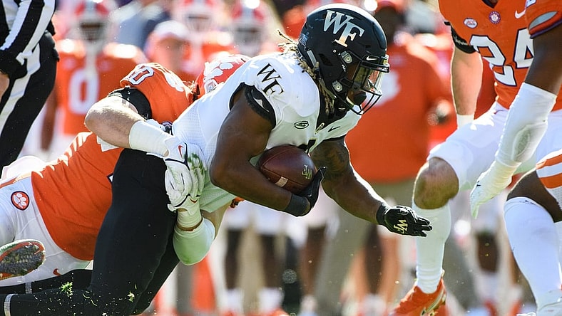 Nov 20, 2021; Clemson, South Carolina, USA;  Wake Forest running back Christian Turner (0) is tackled by Clemson linebacker Baylon Spector (10) during their game at Memorial Stadium. Mandatory Credit: Josh Morgan-USA TODAY Sports