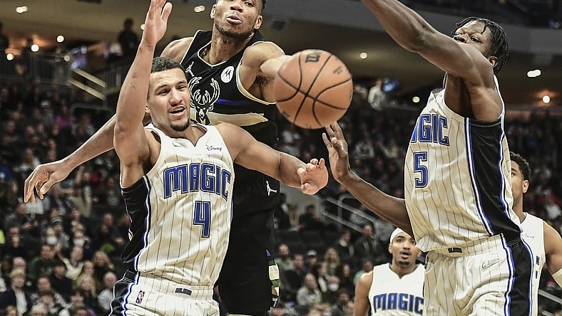 Nov 20, 2021; Milwaukee, Wisconsin, USA; Milwaukee Bucks forward Giannis Antetokounmpo (34) reaches for a rebound against Orlando Magic guard Jalen Suggs (4) and center Mo Bamba (5) in the second quarter at Fiserv Forum. Mandatory Credit: Benny Sieu-USA TODAY Sports
