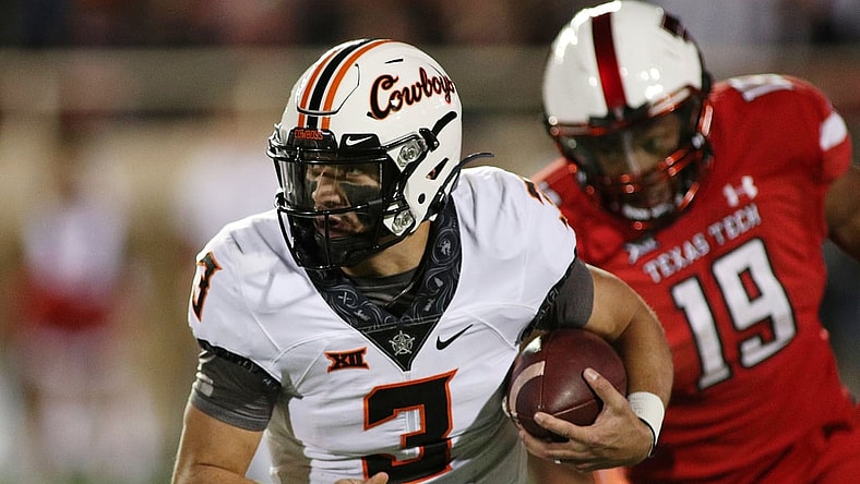 Nov 20, 2021; Lubbock, Texas, USA;  Oklahoma State Cowboys quarterback Spencer Sanders (3) runs the ball against Texas Tech Red Raiders defensive lineman Tyree Wilson (19) in the first half at Jones AT&T Stadium. Mandatory Credit: Michael C. Johnson-USA TODAY Sports