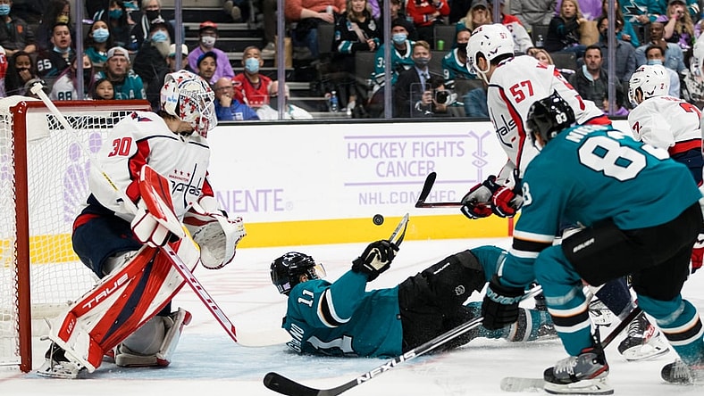 Nov 20, 2021; San Jose, California, USA;  San Jose Sharks center Andrew Cogliano (11) falls as Washington Capitals goaltender Ilya Samsonov (30) and defenseman Trevor van Riemsdyk (57) defend during the second period at SAP Center at San Jose. Mandatory Credit: John Hefti-USA TODAY Sports