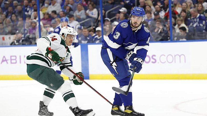 Nov 21, 2021; Tampa, Florida, USA; Tampa Bay Lightning defenseman Fredrik Claesson (3) passes the puck as Minnesota Wild center Joel Eriksson Ek (14) defends during the first period at Amalie Arena. Mandatory Credit: Kim Klement-USA TODAY Sports