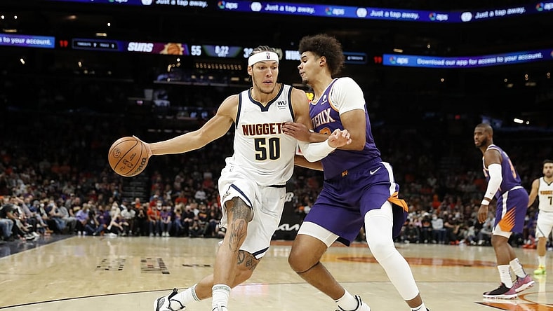 Nov 21, 2021; Phoenix, Arizona, USA; Phoenix Suns forward Cameron Johnson (23) defends Denver Nuggets forward Aaron Gordon (50) during the first half at Footprint Center. Mandatory Credit: Chris Coduto-USA TODAY Sports