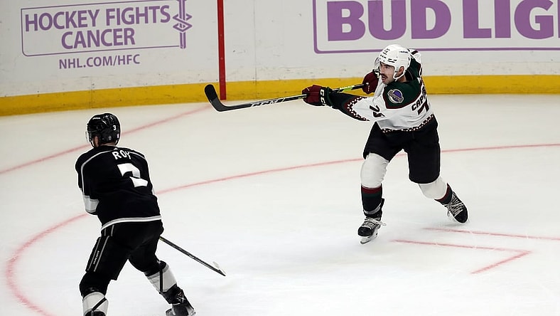 Nov 21, 2021; Los Angeles, California, USA; Arizona Coyotes defenseman Kyle Capobianco (75) shoots the game winning shot in the overtime against the Los Angeles King at Staples Center. The Coyotes wins 2-1. Mandatory Credit: Kiyoshi Mio-USA TODAY Sports