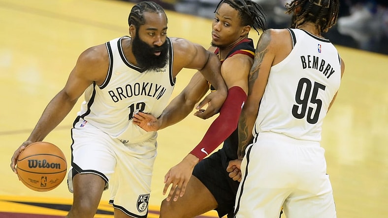 Nov 22, 2021; Cleveland, Ohio, USA; Cleveland Cavaliers guard Darius Garland (10) defends Brooklyn Nets guard James Harden (13) and guard DeAndre' Bembry (95) in the first quarter at Rocket Mortgage FieldHouse. Mandatory Credit: David Richard-USA TODAY Sports