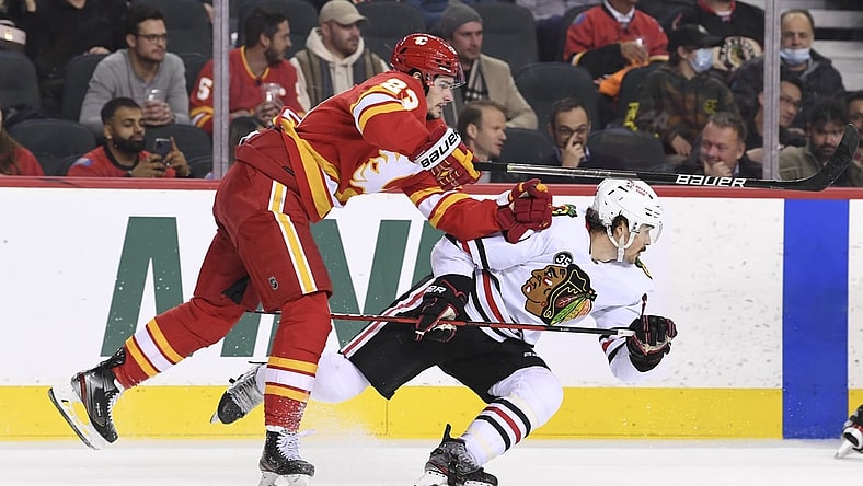 Nov 23, 2021; Calgary, Alberta, CAN; Calgary Flames forward Sean Monahan (23) collides with Chicago Blackhawks forward Ryan Carpenter (22) during the second period at Scotiabank Saddledome. Mandatory Credit: Candice Ward-USA TODAY Sports