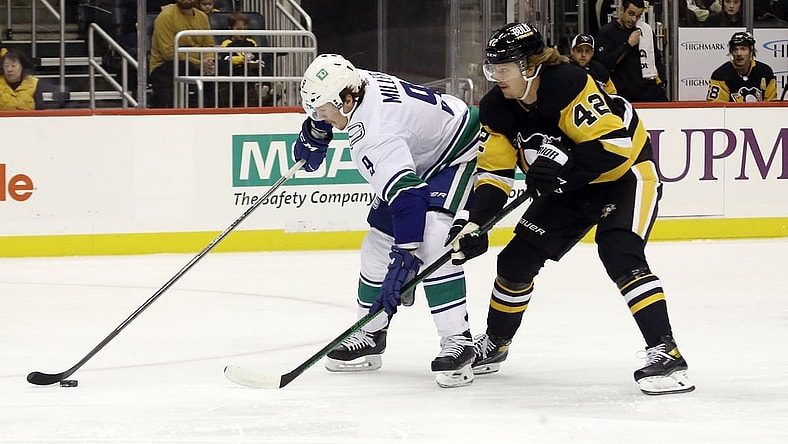 Nov 24, 2021; Pittsburgh, Pennsylvania, USA;  Vancouver Canucks center J.T. Miller (9) moves the puck against Pittsburgh Penguins right wing Kasperi Kapanen (42) during the first period at PPG Paints Arena. Mandatory Credit: Charles LeClaire-USA TODAY Sports