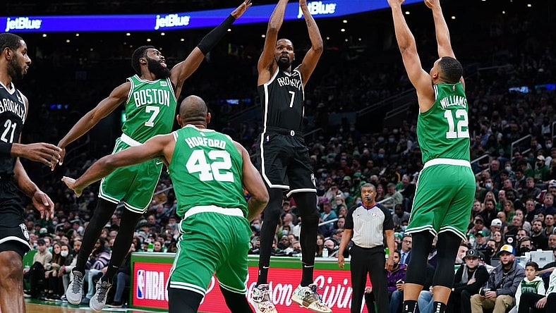 Nov 24, 2021; Boston, Massachusetts, USA; Brooklyn Nets forward Kevin Durant (7) makes the basket against Boston Celtics guard Jaylen Brown (7) and forward Grant Williams (12) in the first half at TD Garden. Mandatory Credit: David Butler II-USA TODAY Sports