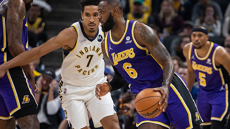 Nov 24, 2021; Indianapolis, Indiana, USA; Los Angeles Lakers forward LeBron James (6) dribbles the ball while Indiana Pacers guard Malcolm Brogdon (7) defends in the first half at Gainbridge Fieldhouse. Mandatory Credit: Trevor Ruszkowski-USA TODAY Sports