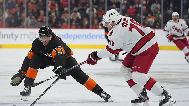 Nov 26, 2021; Philadelphia, Pennsylvania, USA; Philadelphia Flyers center Zack MacEwen (17) reaches for the puck against Carolina Hurricanes defenseman Brady Skjei (76) in the first period at the Wells Fargo Center. Mandatory Credit: Mitchell Leff-USA TODAY Sports