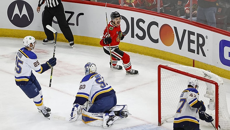 Nov 26, 2021; Chicago, Illinois, USA; Chicago Blackhawks left wing Alex DeBrincat (12) celebrates after scoring a goal in overtime against the St. Louis Blues at United Center. Mandatory Credit: Kamil Krzaczynski-USA TODAY Sports