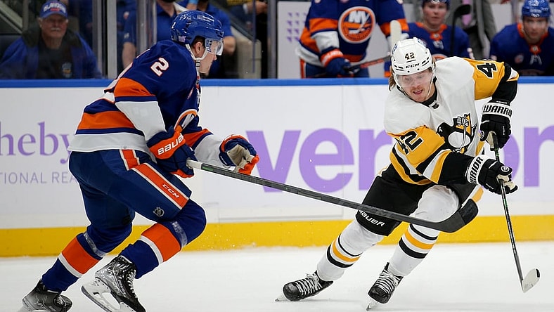 Nov 26, 2021; Elmont, New York, USA; Pittsburgh Penguins right wing Kasperi Kapanen (42) plays the puck against New York Islanders defenseman Robin Salo (2) during the first period at UBS Arena. Mandatory Credit: Brad Penner-USA TODAY Sports