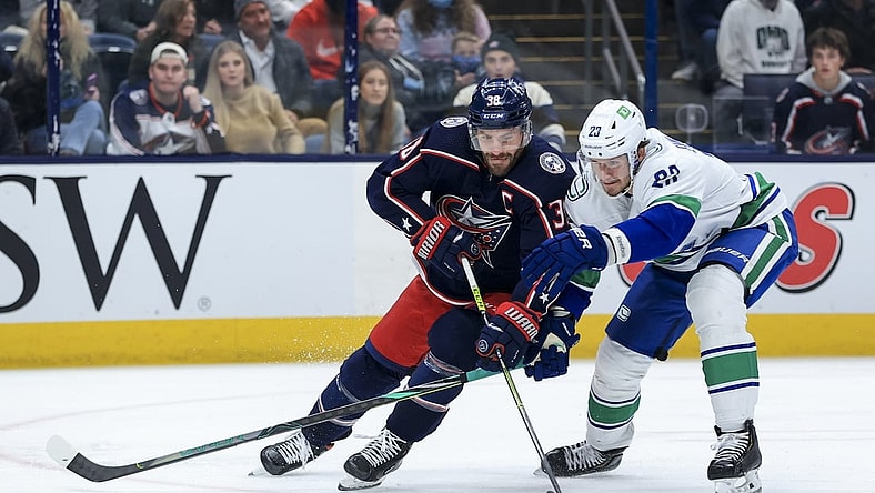 Nov 26, 2021; Columbus, Ohio, USA; Columbus Blue Jackets center Boone Jenner (38) skates against Vancouver Canucks defenseman Oliver Ekman-Larsson (23) in the second period at Nationwide Arena. Mandatory Credit: Aaron Doster-USA TODAY Sports