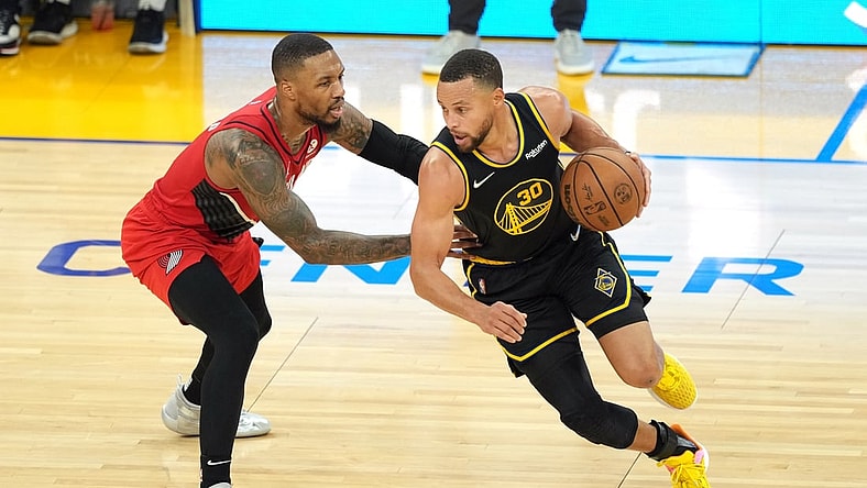 Nov 26, 2021; San Francisco, California, USA; Golden State Warriors guard Stephen Curry (30) dribbles while being defended by Portland Trail Blazers guard Damian Lillard (0) during the second quarter at Chase Center. Mandatory Credit: Darren Yamashita-USA TODAY Sports