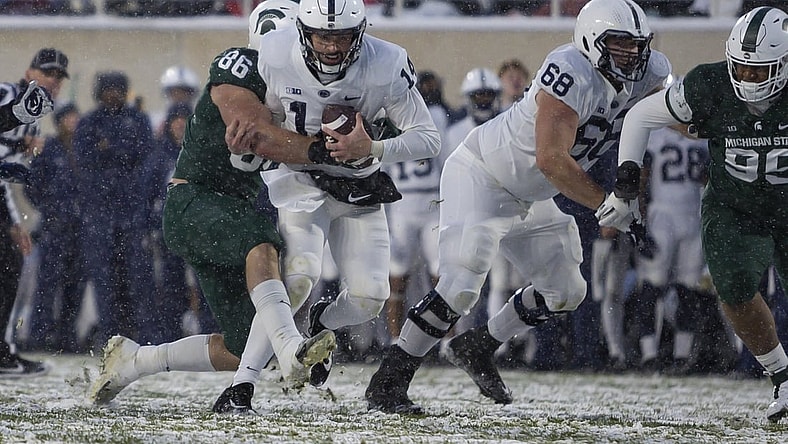 Nov 27, 2021; East Lansing, Michigan, USA; Penn State Nittany Lions quarterback Sean Clifford (14) gets wrapped up by Michigan State Spartans defensive end Drew Beesley (86) during the second quarter at Spartan Stadium. Mandatory Credit: Raj Mehta-USA TODAY Sports