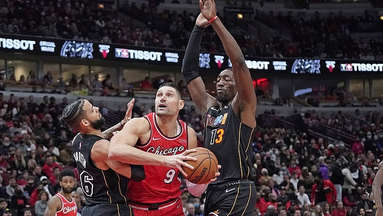 Nov 27, 2021; Chicago, Illinois, USA; Chicago Bulls center Nikola Vucevic (9) is defended by Miami Heat forward Caleb Martin (16) and center Bam Adebayo (13) during the first half at United Center. Mandatory Credit: David Banks-USA TODAY Sports