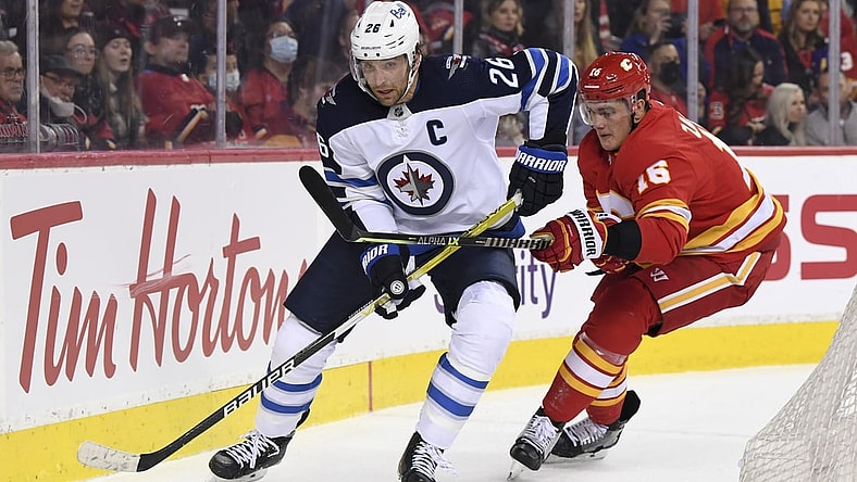 Nov 27, 2021; Calgary, Alberta, CAN; Winnipeg Jets forward Blake Wheeler (26) battles for the puck with Calgary Flames defenseman Nikita Zadorov (16) during the first period at Scotiabank Saddledome. Mandatory Credit: Candice Ward-USA TODAY Sports