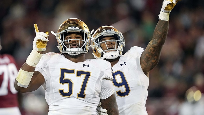 Nov 27, 2021; Stanford, California, USA; Notre Dame Fighting Irish defensive lineman Jayson Ademilola (57) celebrates with defensive lineman Justin Ademilola (9) after a sack during the third quarter against the Stanford Cardinal at Stanford Stadium. Mandatory Credit: Darren Yamashita-USA TODAY Sports