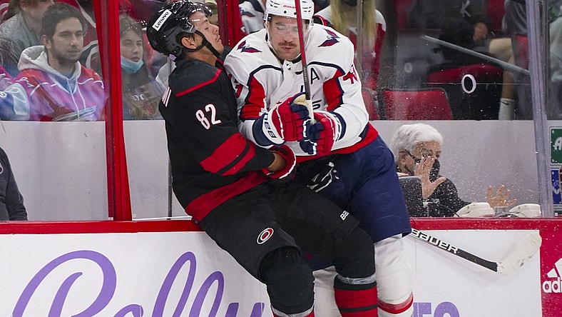 Nov 28, 2021; Raleigh, North Carolina, USA;  Washington Capitals right wing Tom Wilson (43) checks Carolina Hurricanes center Jesperi Kotkaniemi (82) during the first period at PNC Arena. Mandatory Credit: James Guillory-USA TODAY Sports