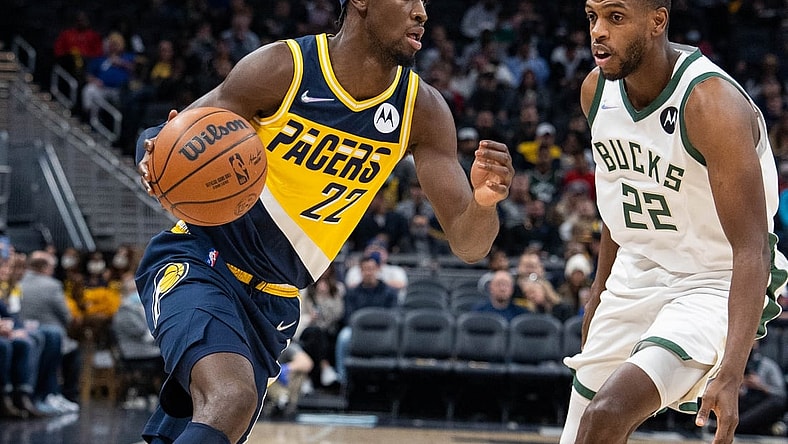 Nov 28, 2021; Indianapolis, Indiana, USA; Indiana Pacers guard Caris LeVert (22) dribbles the ball while Milwaukee Bucks forward Khris Middleton (22) defends in the first quarter at Gainbridge Fieldhouse. Mandatory Credit: Trevor Ruszkowski-USA TODAY Sports