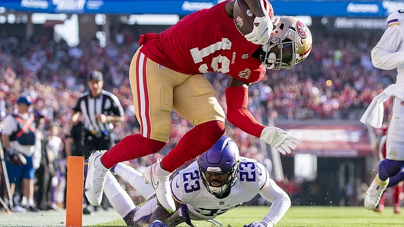 November 28, 2021; Santa Clara, California, USA; San Francisco 49ers wide receiver Deebo Samuel (19) scores a touchdown against Minnesota Vikings free safety Xavier Woods (23) during the first quarter at Levi's Stadium. Mandatory Credit: Kyle Terada-USA TODAY Sports