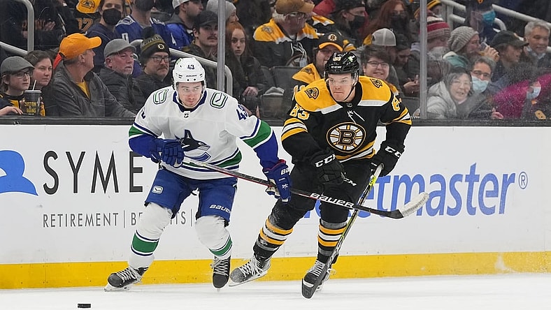 Nov 28, 2021; Boston, Massachusetts, USA; Vancouver Canucks defenseman Quinn Hughes (43) and Boston Bruins right wing Karson Kuhlman (83) chase the puck during the first period at TD Garden. Mandatory Credit: Gregory Fisher-USA TODAY Sports