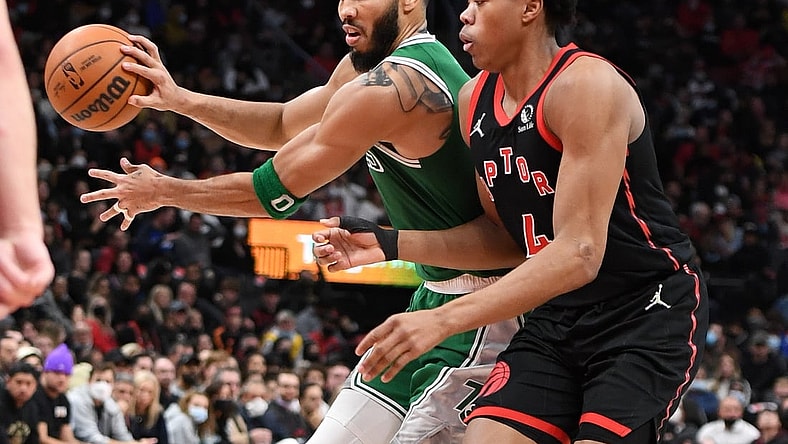 Nov 28, 2021; Toronto, Ontario, CAN;  Boston Celtics forward Jayson Tatum (0) passes the ball away from Toronto Raptors forward Scottie Barnes (4) in the second half at Scotiabank Arena. Mandatory Credit: Dan Hamilton-USA TODAY Sports