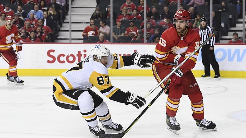 Nov 29, 2021; Calgary, Alberta, CAN; Calgary Flames defenseman Noah Hanifin (55) defends against Pittsburgh Penguins forward Sidney Crosby (87) during the second period at Scotiabank Saddledome. Mandatory Credit: Candice Ward-USA TODAY Sports