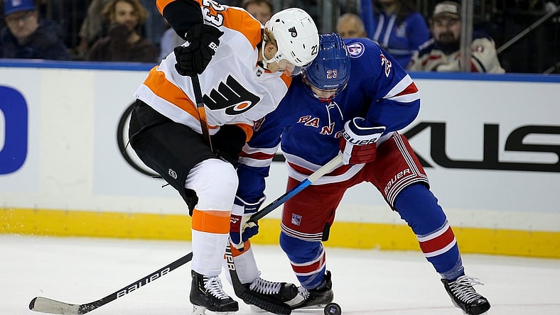 Dec 1, 2021; New York, New York, USA; Philadelphia Flyers left wing Oskar Lindblom (23) and New York Rangers defenseman Adam Fox (23) fight for the puck during the first period at Madison Square Garden. Mandatory Credit: Brad Penner-USA TODAY Sports