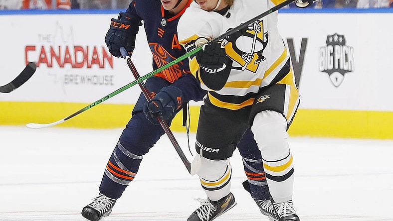 Dec 1, 2021; Edmonton, Alberta, CAN; Pittsburgh Penguins forward Kasperi Kapanen (42) and Edmonton Oilers forward Ryan Nugent-Hopkins (93) battle for a loose puck during the first period at Rogers Place. Mandatory Credit: Perry Nelson-USA TODAY Sports