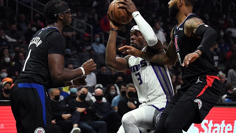 Dec 1, 2021; Los Angeles, California, USA; Sacramento Kings forward Terence Davis (3) drives to the basket while defended by Los Angeles Clippers guard Reggie Jackson (1) and forward Marcus Morris (8) during the third quarter at Staples Center. Mandatory Credit: Richard Mackson-USA TODAY Sports