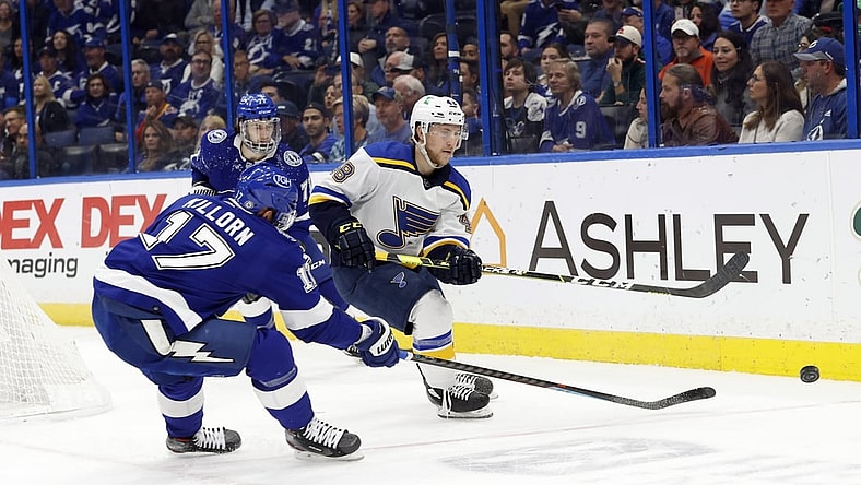 Dec 2, 2021; Tampa, Florida, USA; St. Louis Blues defenseman Scott Perunovich (48) passes the puck as Tampa Bay Lightning left wing Alex Killorn (17) defends during the first period at Amalie Arena. Mandatory Credit: Kim Klement-USA TODAY Sports