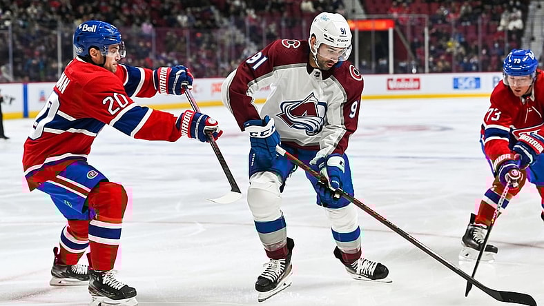 Dec 2, 2021; Montreal, Quebec, CAN; Colorado Avalanche center Nazem Kadri (91) plays the puck against Montreal Canadiens defenceman Chris Wideman (20) during the first period at Bell Centre. Mandatory Credit: David Kirouac-USA TODAY Sports