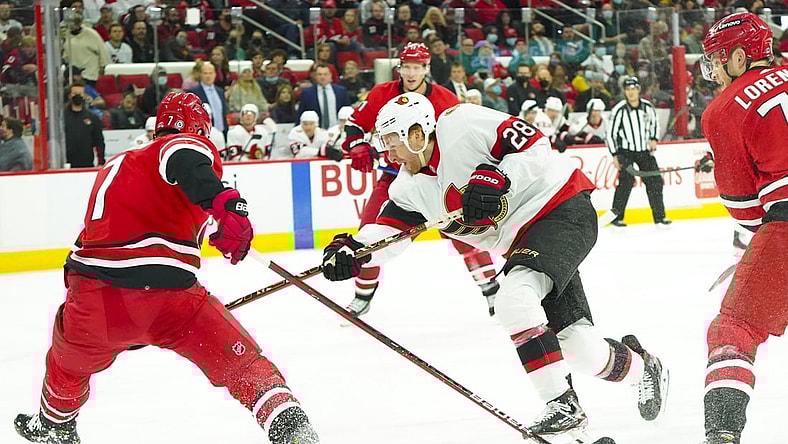 Dec 2, 2021; Raleigh, North Carolina, USA;  Ottawa Senators right wing Connor Brown (28) shoots against Carolina Hurricanes defenseman Brendan Smith (7) during the second period at PNC Arena. Mandatory Credit: James Guillory-USA TODAY Sports