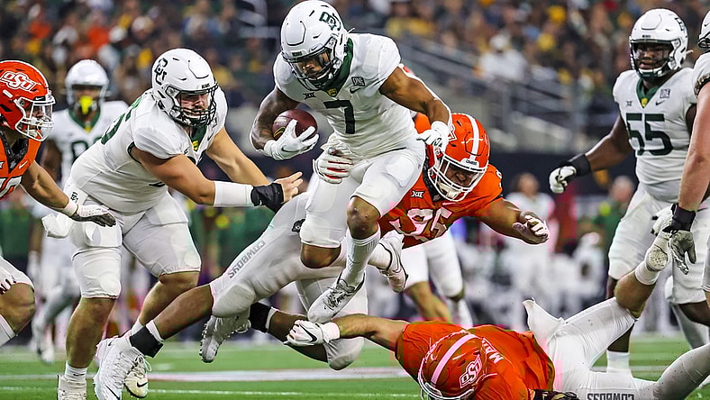 Dec 4, 2021; Arlington, TX, USA; Baylor Bears running back Abram Smith (7) hurdles Oklahoma State Cowboys defensive tackle Israel Antwine (95) during the first half of the Big 12 Conference championship game at AT&T Stadium. Mandatory Credit: Kevin Jairaj-USA TODAY Sports