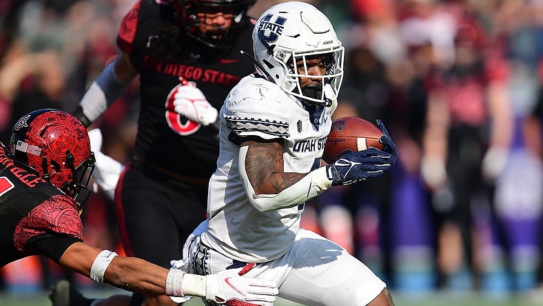 Dec 4, 2021; Carson, CA, USA; Utah State Aggies running back Calvin Tyler Jr. (4) runs the ball against San Diego State Aztecs safety C.J. Baskerville (34) during the first half of the Mountain West Conference championship game at Dignity Health Sports Park. Mandatory Credit: Gary A. Vasquez-USA TODAY Sports