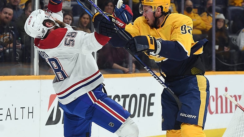 Dec 4, 2021; Nashville, Tennessee, USA; Nashville Predators center Ryan Johansen (92) is called for a high stick after a hit on Montreal Canadiens defenseman David Savard (58) during the first period at Bridgestone Arena. Mandatory Credit: Christopher Hanewinckel-USA TODAY Sports