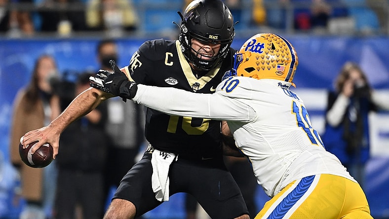 Dec 4, 2021; Charlotte, NC, USA; Wake Forest Demon Deacons quarterback Sam Hartman (10) is sacked by Pittsburgh Panthers defensive lineman Keyshon Camp (10) in the third quarter of the ACC championship game at Bank of America Stadium. Mandatory Credit: Bob Donnan-USA TODAY Sports
