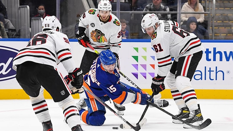 Dec 5, 2021; Elmont, New York, USA;  New York Islanders right wing Cal Clutterbuck (15) attempts to shoot the puck from his knees defended by Chicago Blackhawks defenseman Riley Stillman (61) during the second period at UBS Arena. Mandatory Credit: Dennis Schneidler-USA TODAY Sports