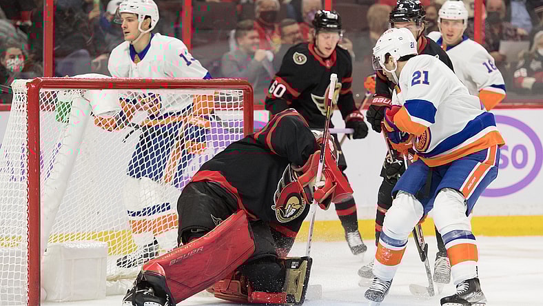 Dec 7, 2021; Ottawa, Ontario, CAN; Ottawa Senators goalie Filip Gustavsson (32) makes a save in front of New York Islanders center Kyle Palmieri (21) in the first period at the Canadian Tire Centre. Mandatory Credit: Marc DesRosiers-USA TODAY Sports
