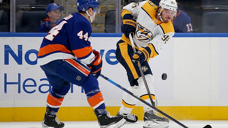 Dec 9, 2021; Elmont, New York, USA; Nashville Predators center Matt Duchene (95) passes the puck past New York Islanders center Jean-Gabriel Pageau (44) during the first period at UBS Arena. Mandatory Credit: Brad Penner-USA TODAY Sports