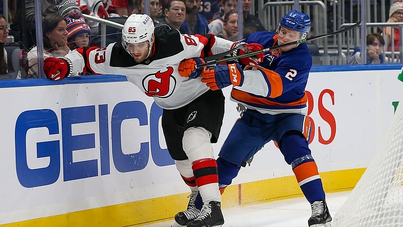 Dec 11, 2021; Elmont, New York, USA; New Jersey Devils defenseman Christian Jaros (83) and New York Islanders defenseman Robin Salo (2) battle for the puck along the boards during the first period at UBS Arena. Mandatory Credit: Tom Horak-USA TODAY Sports