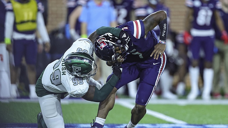 Dec 18, 2021; Mobile, Alabama, USA; Liberty Flames quarterback Malik Willis (7) is pressured by Eastern Michigan Eagles defensive lineman Turan Rush (99) in the first quarter during the 2021 LendingTree Bowl at Hancock Whitney Stadium. Mandatory Credit: Robert McDuffie-USA TODAY Sports