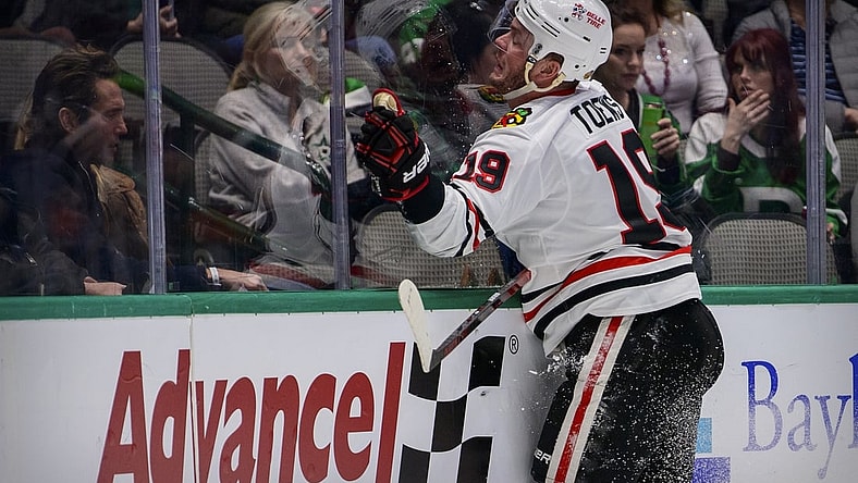 Dec 18, 2021; Dallas, Texas, USA; Chicago Blackhawks center Jonathan Toews (19) crashes into the glass during the third period against the Dallas Stars at the American Airlines Center. Mandatory Credit: Jerome Miron-USA TODAY Sports