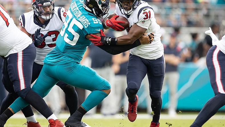 Dec 19, 2021; Jacksonville, Florida, USA; Houston Texans running back David Johnson (31) runs past Jacksonville Jaguars defensive end Roy Robertson-Harris (95) during the first half at TIAA Bank Field. Mandatory Credit: Matt Pendleton-USA TODAY Sports